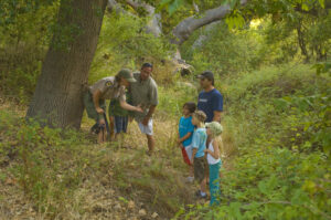 Docents speaking to a group of children and a chaperone