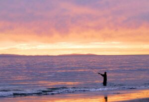 Fisherman on the shore during sunset