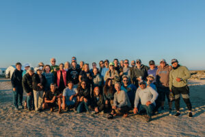 Large group of people posing on the beach