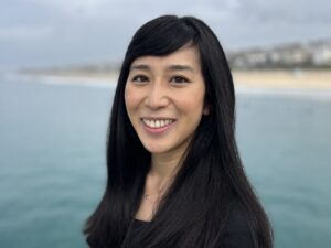Rosanna Xia smiling in front of an overcast beach background