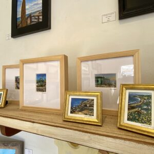 Framed artwork displayed on a wall shelf