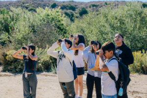 Children looking off in the distance through binoculars