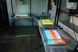 Tables with bins of sand on top. Colored topography graphs projected onto the sand