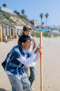 Students measuring the coastline and sea level with tools