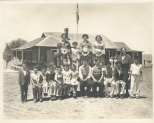 Group of Japanese children standing in front of a school house