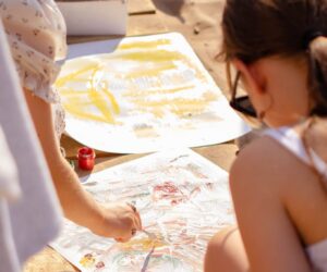 Kids painting on a bright beach