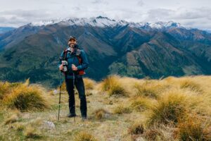 Man wearing hiking gear standing in front of a mountain
